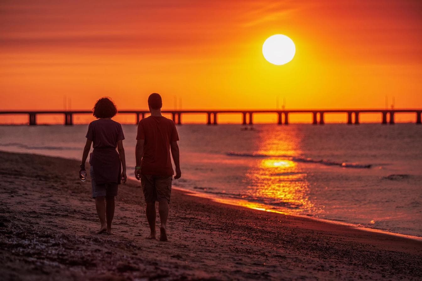 Couple walking the beach at sunset